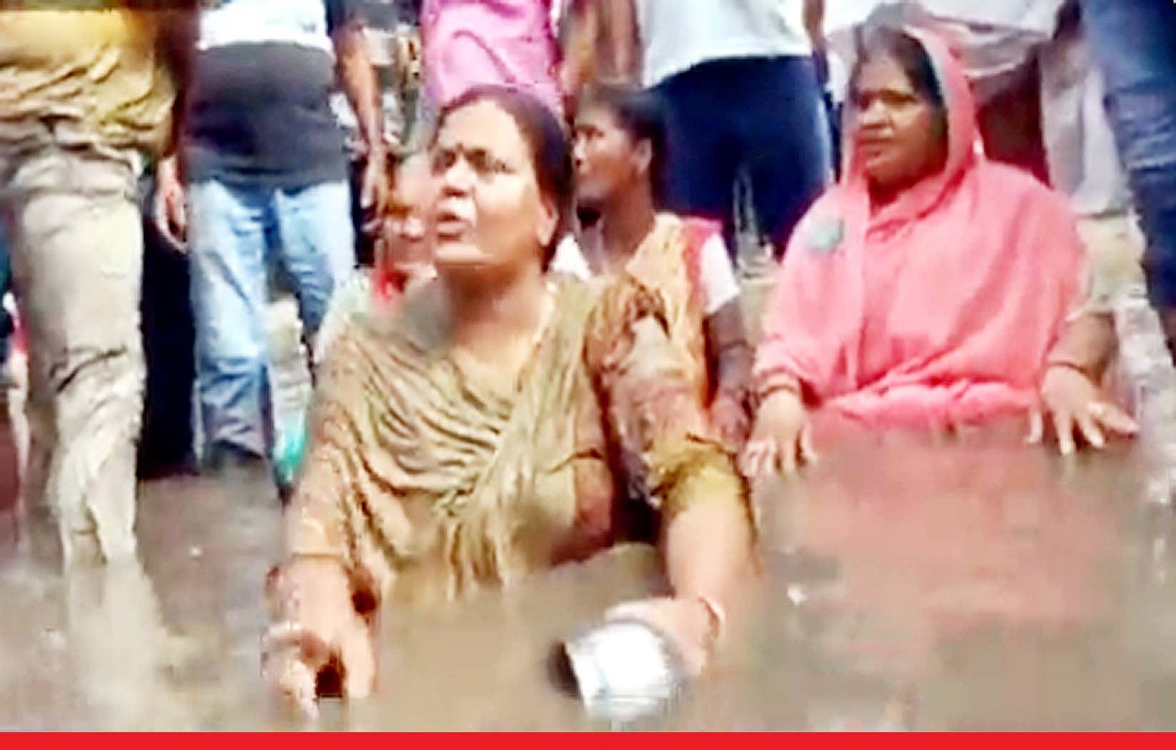 कांग्रेस की विधायक का अनोखा विरोध प्रदर्शन : बीच सड़क पर गंदे पानी में बैठकर नहाने लगी